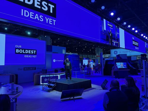Rows of press seating filled with laptops and reporters facing a stage.