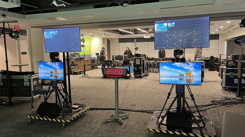 A live production console with multiviewer monitors and colourful graphics mid-show.
